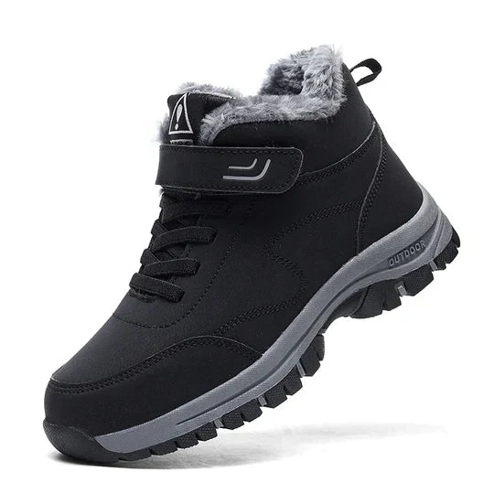 Black high-top boot with fluffy grey lining, hook-and-loop strap, laces and chunky grey tread, side view 1
