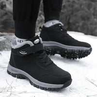 Person wearing black fleece-lined boots with strap and laces, walking on snow 4