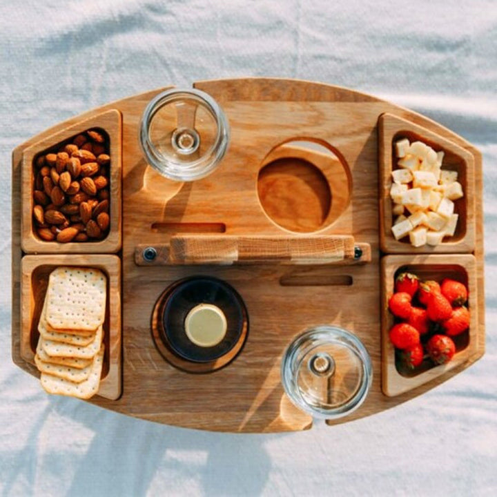 Top-down view of the wooden table with almonds, crackers, cheese cubes, strawberries, two glasses and the bottle slot 6