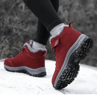 Person in red fleece-lined boots walking through snow, raised heel showing the deep tread 6