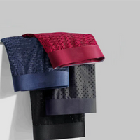 Navy, red, grey and black mesh boxer shorts folded and layered over a white ledge, showing their wide waistbands 3