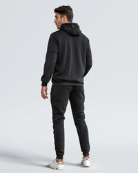 Back view of a model wearing a black hooded tracksuit with ribbed hem and cuffs 21