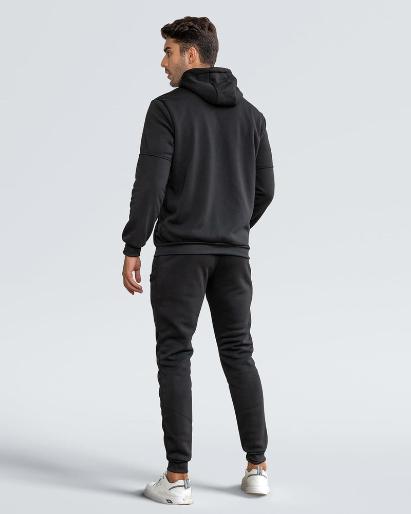 Back view of a model wearing the black hooded tracksuit with slim joggers and white trainers 22