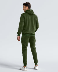 Back view of the green hooded tracksuit worn by a model looking over his shoulder 16