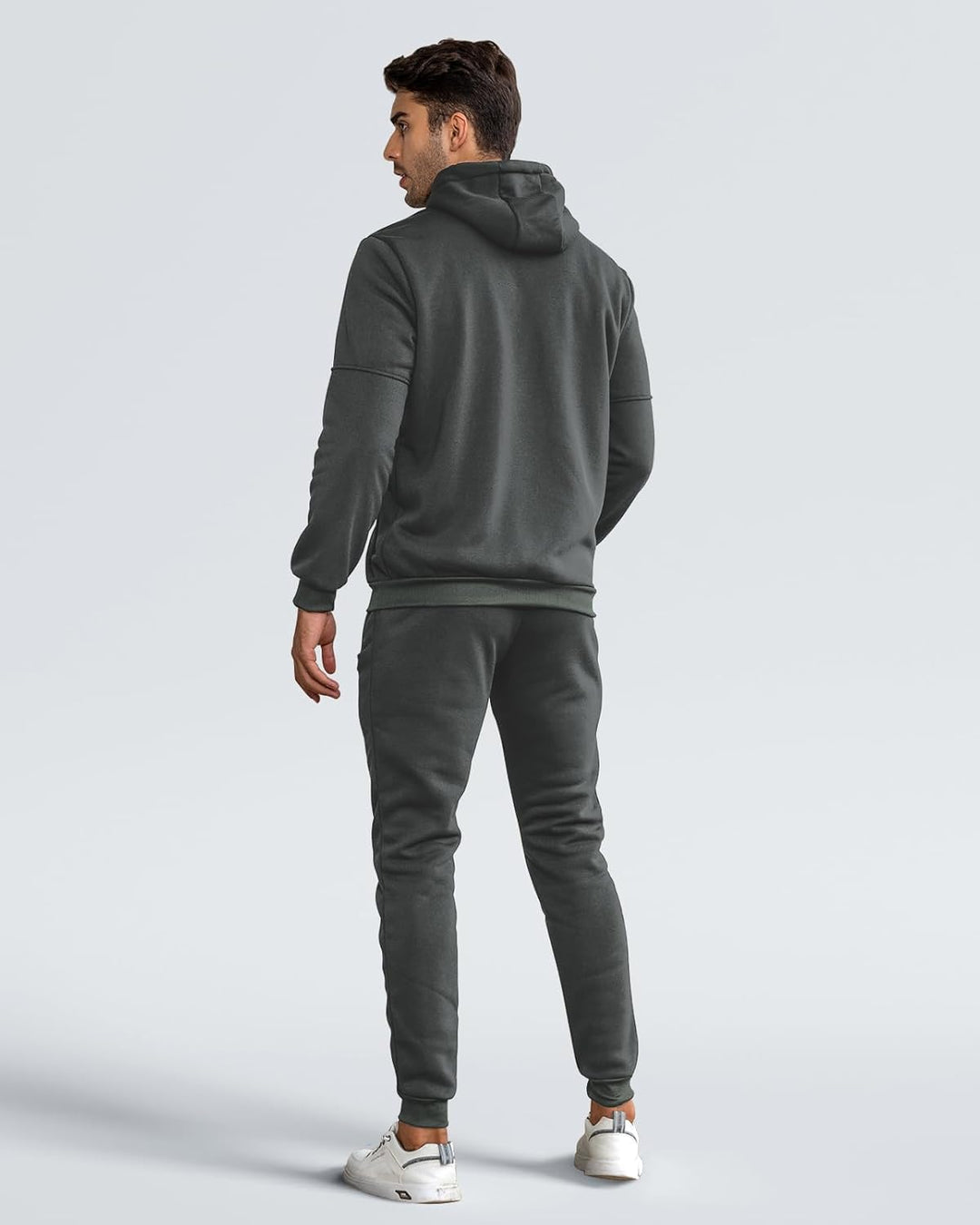 Back view of the dark grey tracksuit on a model, showing hood, seamed sleeves and ribbed hem 5