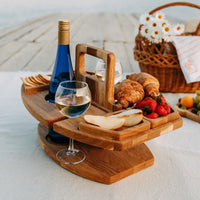 Wooden drinks table on a picnic blanket with wine, croissants, strawberries, pear slices and a wicker basket 2