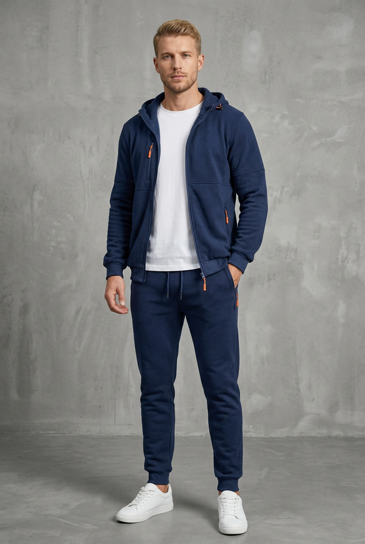 Front view of a navy zip-up hoodie and joggers with orange zips, worn over a white tee 2