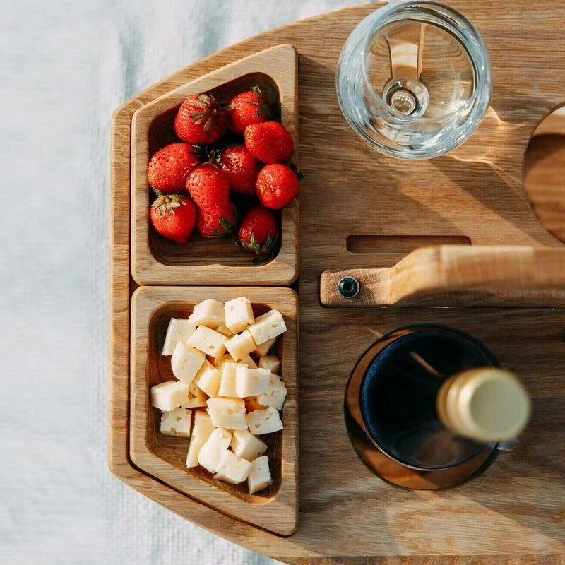 Close-up from above of two snack trays holding strawberries and cheese cubes, next to the handle and bottle 9