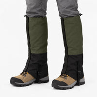 Olive green and black gaiters worn over hiking boots on a white background, with drawcords and instep straps 10