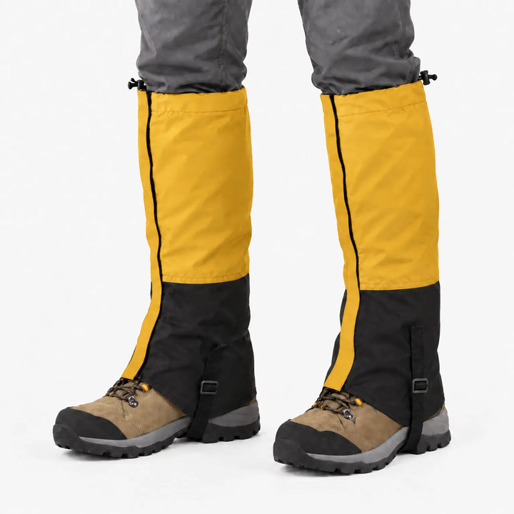 Mustard yellow and black gaiters worn over hiking boots on a white background, with drawcords and instep straps 13