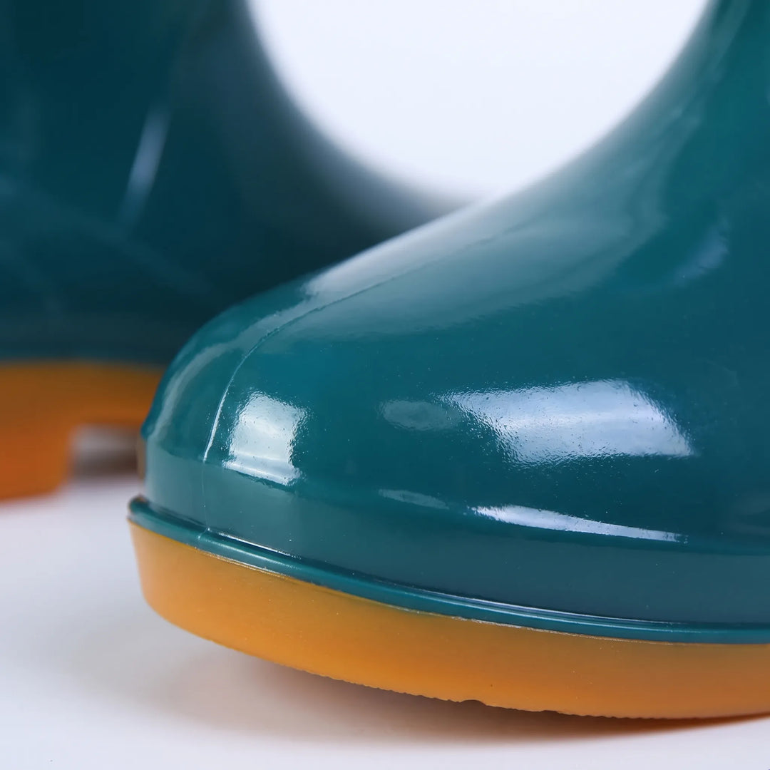 Close-up of the glossy teal rubber toe cap and orange sole edge, showing the shiny surface and seam. 5