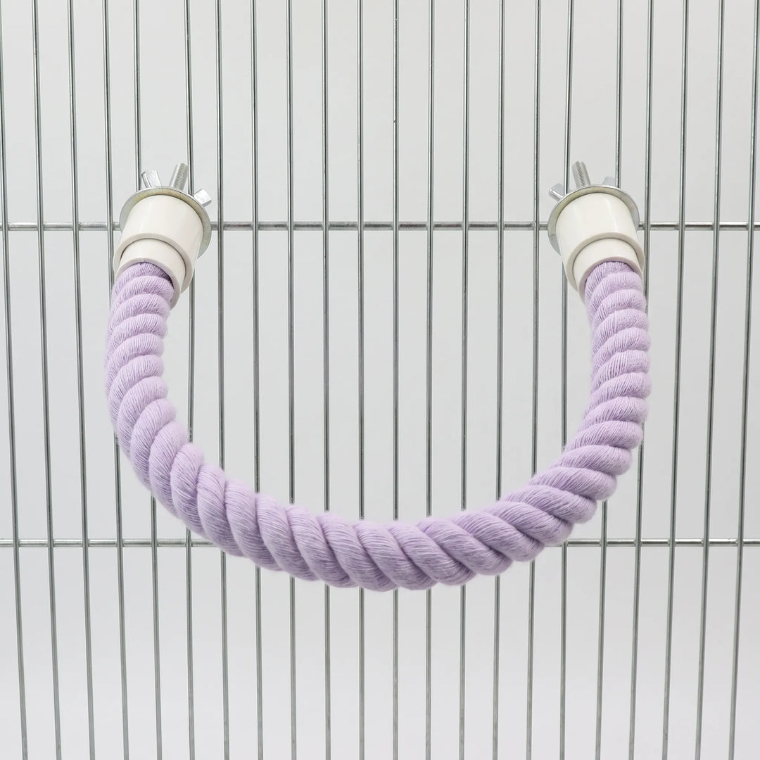 Lilac rope perch bent into a U-shape and bolted to the bars of a metal cage using wing nuts. 5