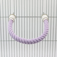 Lilac rope perch bent into a U-shape and bolted to the bars of a metal cage using wing nuts. 5