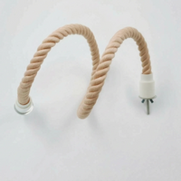 Peach-toned twisted rope perch bent into a wavy, flexible shape, showing one white end cap with bolt and one clear fitting. 6