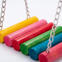 Close-up of the swing's painted wooden rods in yellow, pink, red, green, blue and red, joined by metal chains against a white background. 3