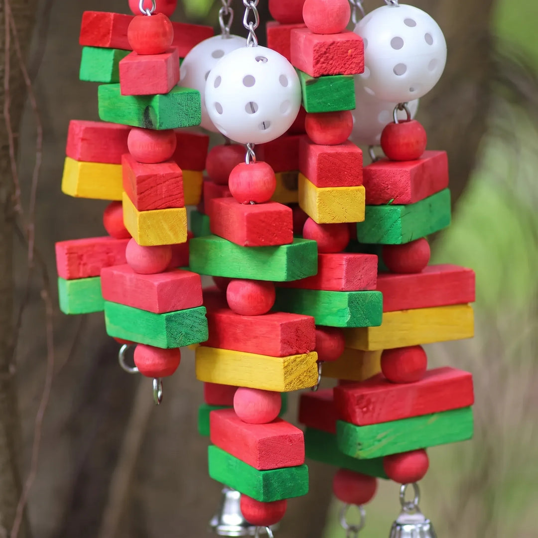 Close-up of red, green and yellow wooden blocks, red beads and white perforated plastic balls strung on chains. 4