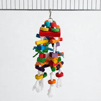 Parrot toy hanging from a cage bar by a metal clip, with coloured wooden blocks, beads and knotted white rope. 1
