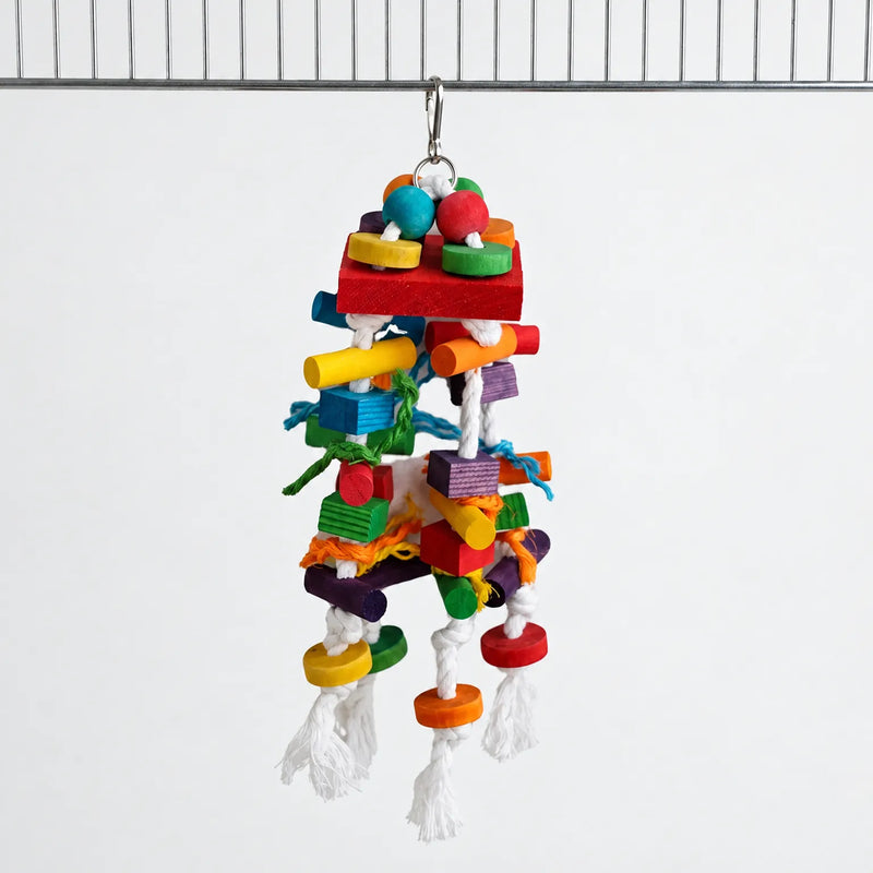Parrot toy hanging from a cage bar by a metal clip, with coloured wooden blocks, beads and knotted white rope. 1