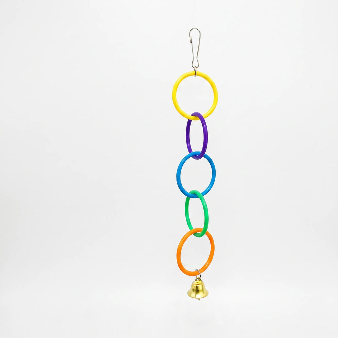 Chain of five linked plastic rings in yellow, purple, blue, green and orange with a small gold bell, hanging on a white background. 1