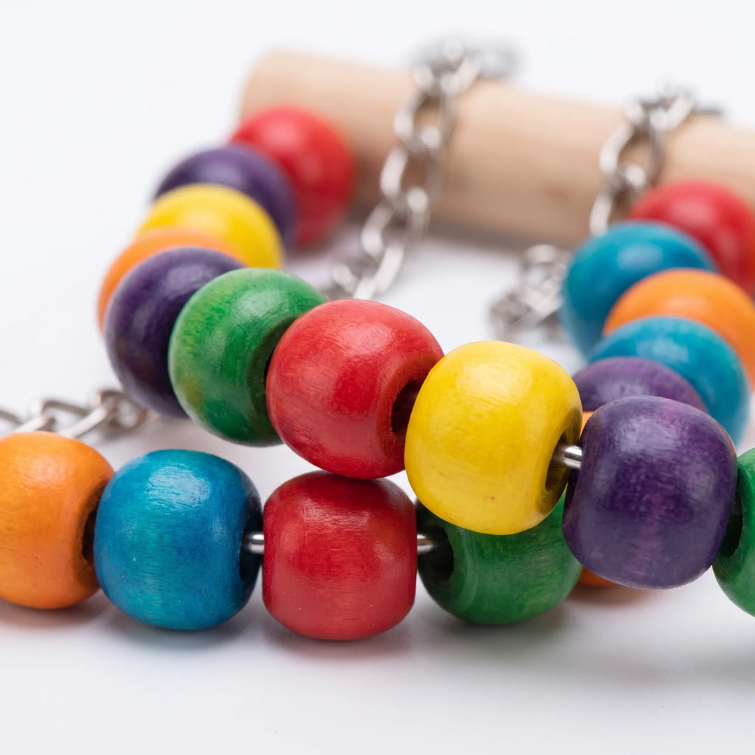 Close-up of the colourful wooden beads threaded on metal chain, with a plain wooden bar behind. 4