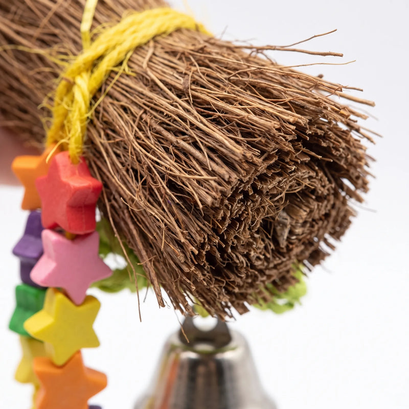 Close-up of the bundled brown natural fibre bristles tied with yellow cord, with coloured star beads and a metal bell below. 2