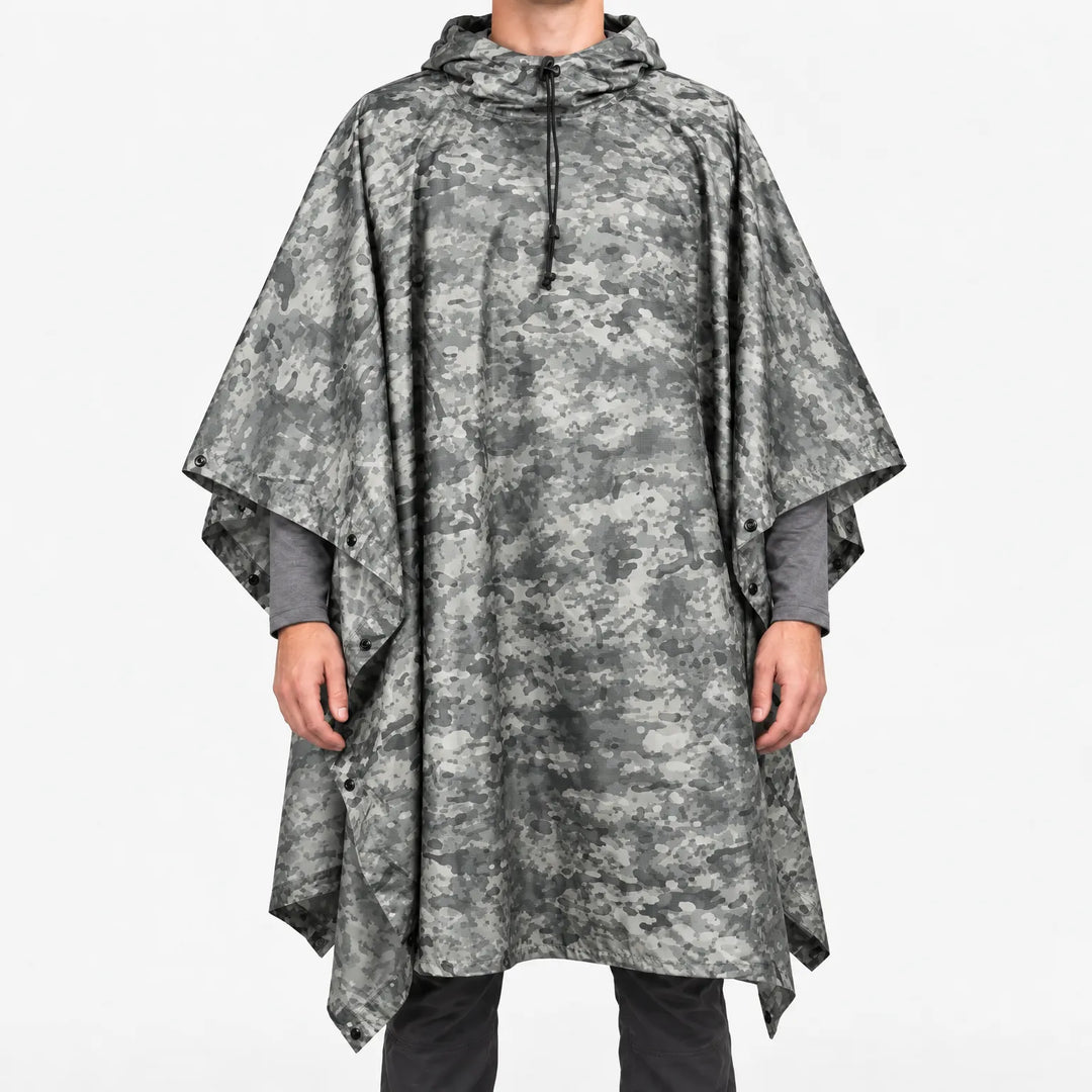 Front view of the hooded poncho in a grey urban digital camouflage pattern, worn over a grey long-sleeve shirt. 12