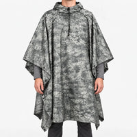 Front view of the hooded poncho in a grey urban digital camouflage pattern, worn over a grey long-sleeve shirt. 12
