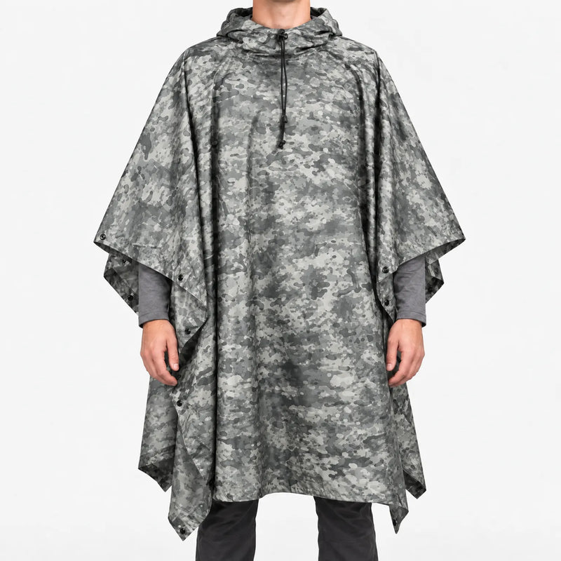 Front view of the hooded poncho in a grey urban digital camouflage pattern, worn over a grey long-sleeve shirt. 12