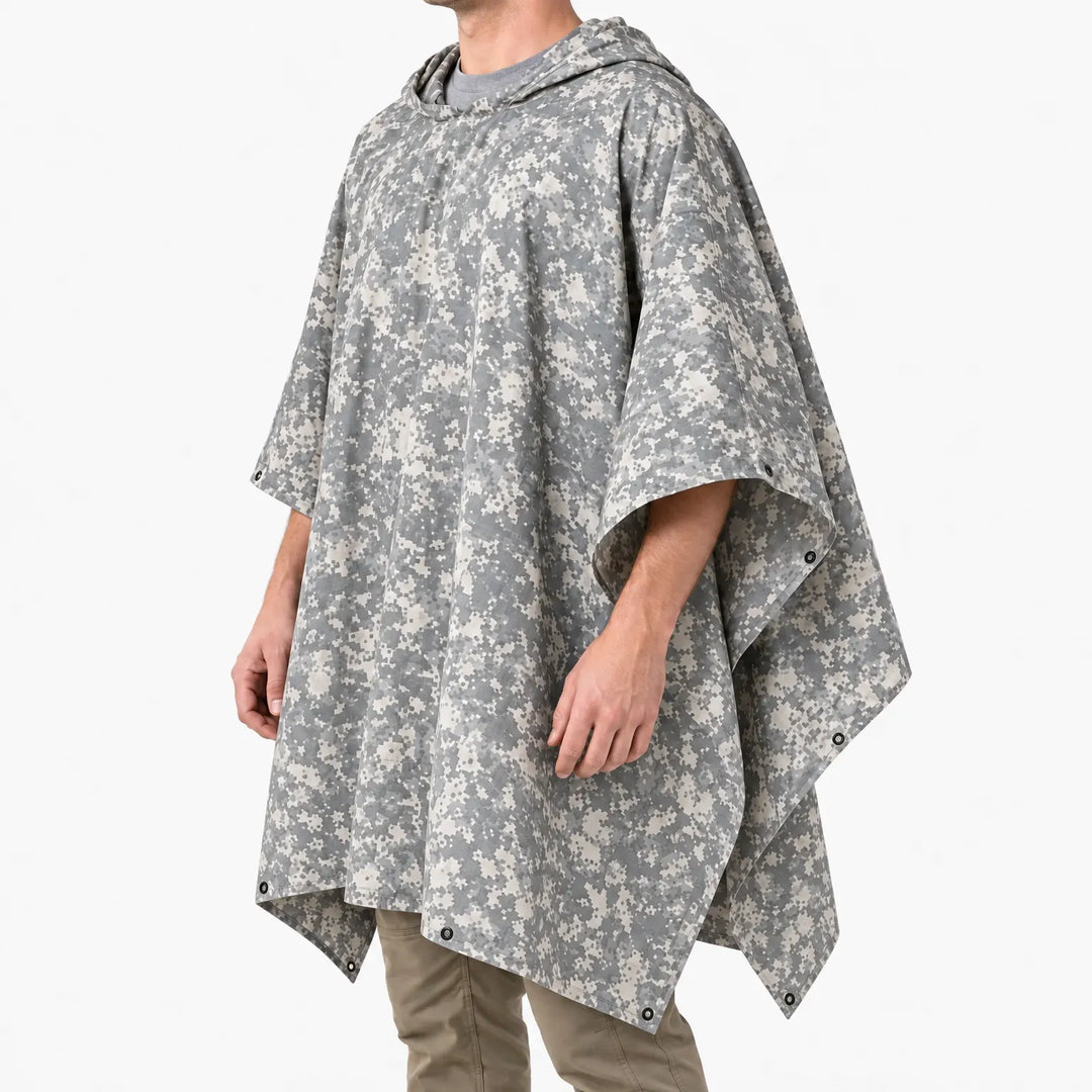 Three-quarter side view of the hooded poncho in pale grey digital camouflage, showing the wide cut and metal eyelets at the corners. 5