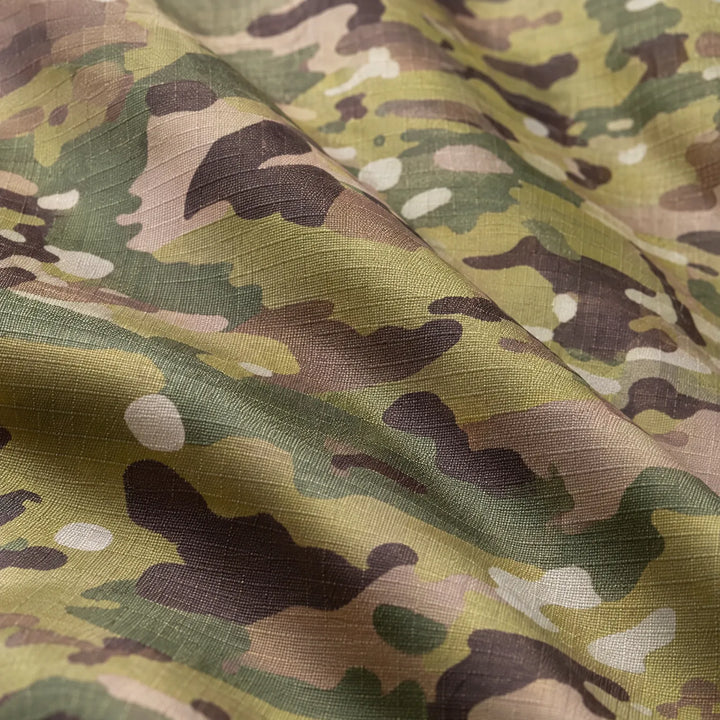 Close-up of the camouflage fabric in green, tan and brown, showing the woven ripstop texture and soft folds. 6