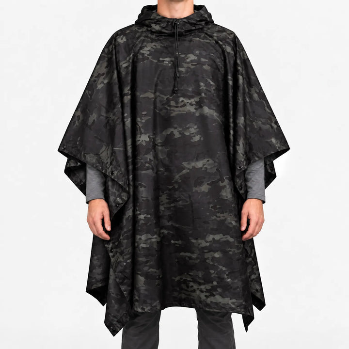 Front view of the hooded poncho in a black and dark grey camouflage pattern, worn over a grey long-sleeve shirt. 8