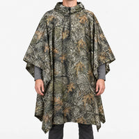 Front view of the hooded poncho in a woodland tree-bark and oak leaf camouflage pattern on a model against white. 9