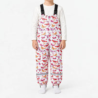 Child in white dungarees covered in pink, red and orange butterflies, with black buckled straps and a reflective strip at each ankle. 14