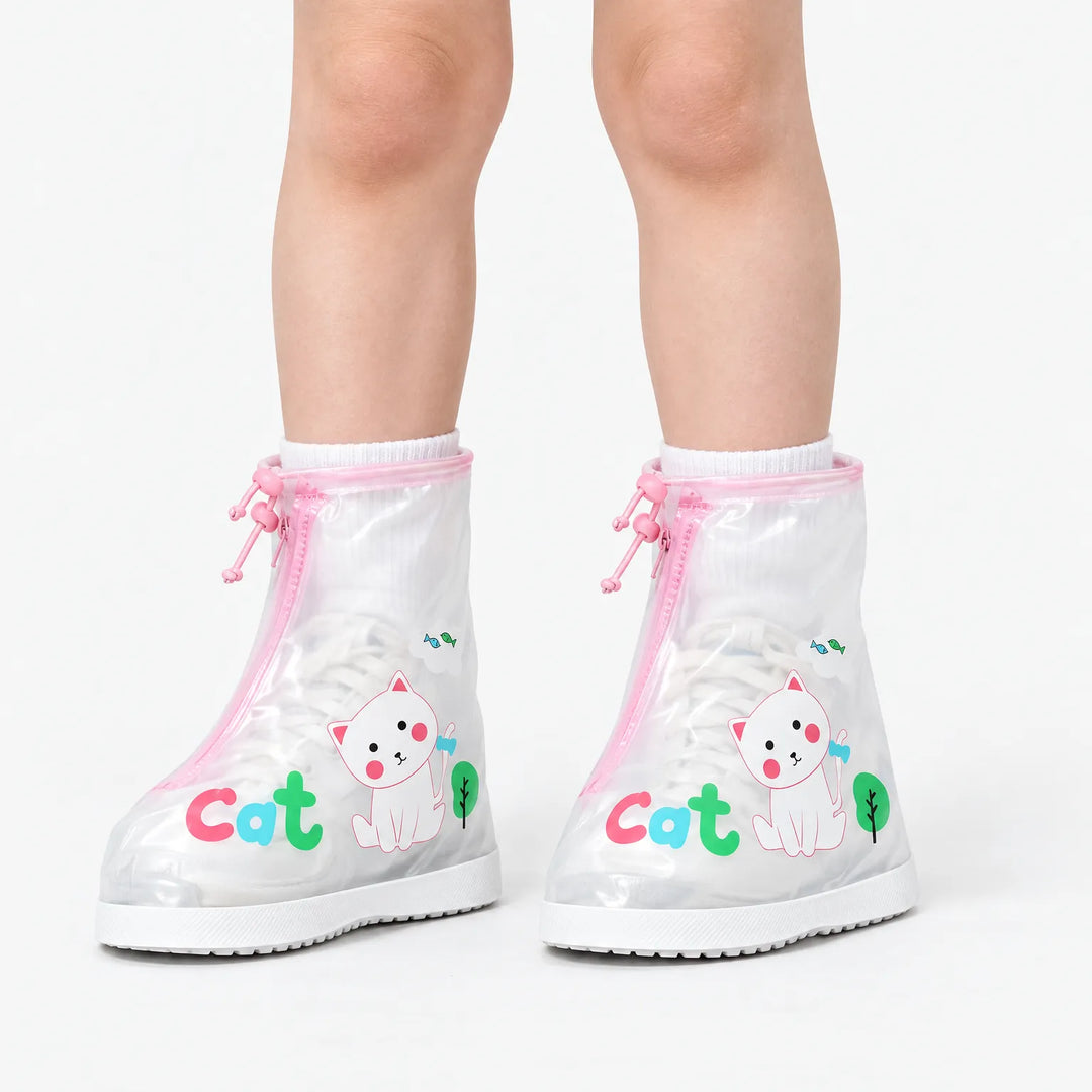 Child wearing clear shoe covers with pink trim and a white cat print over white sneakers, shown against a plain white background. 2
