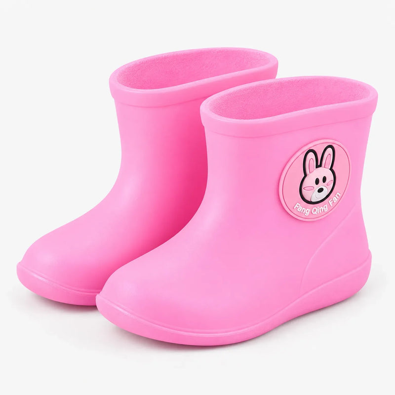 Pair of pink rain boots at a three-quarter angle, with a round rabbit badge on the shaft and a rounded toe. 10