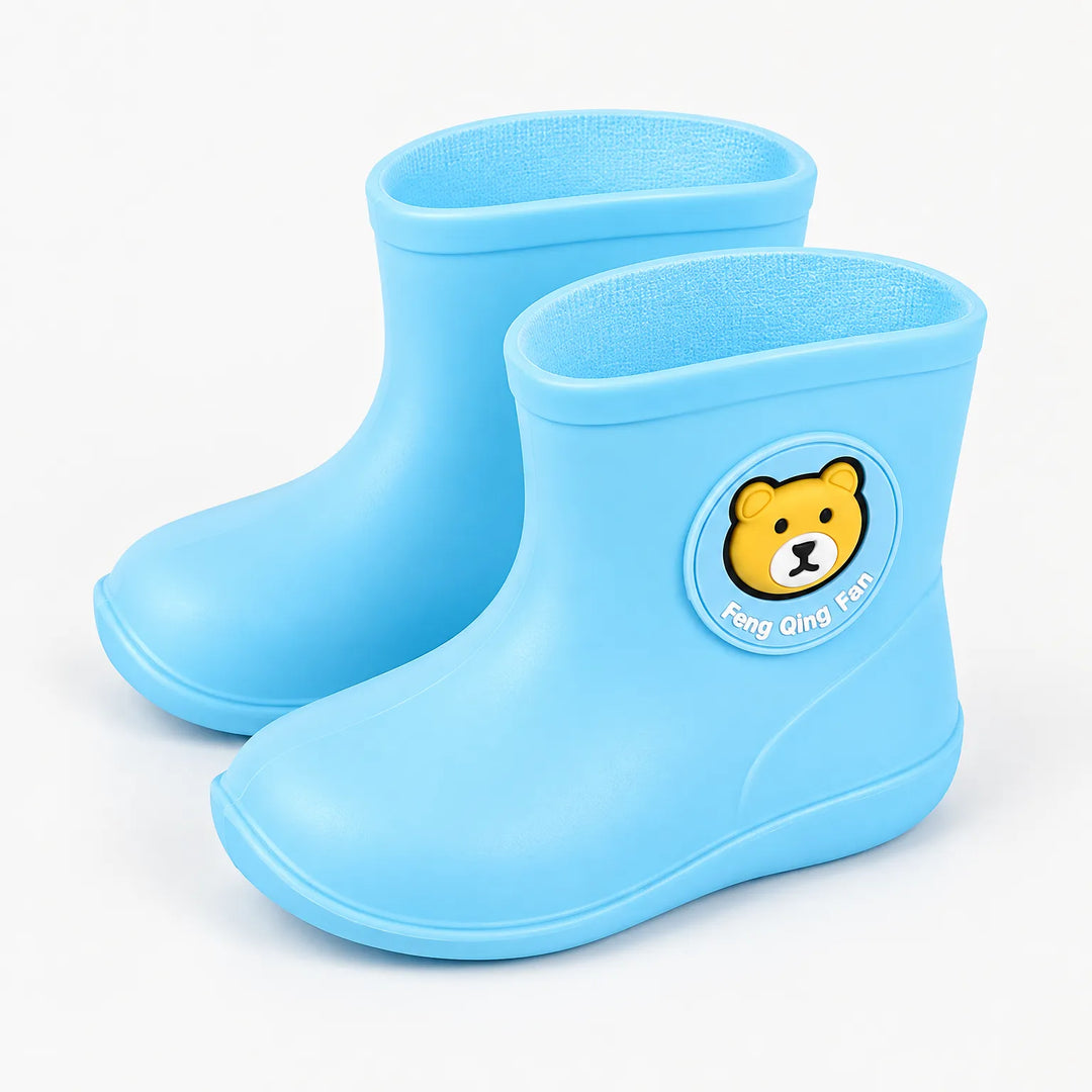 Pair of light blue rain boots at an angle, showing the round bear badge on the side and the soft lining. 2