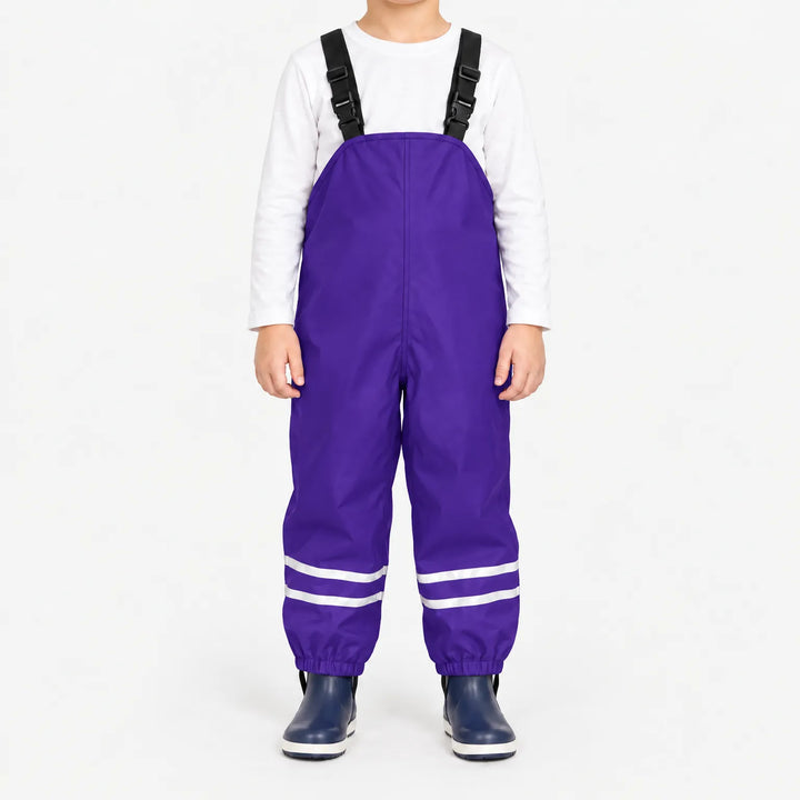 Child facing front in purple waterproof dungarees with adjustable black straps, reflective ankle stripes and navy boots, white background. 12