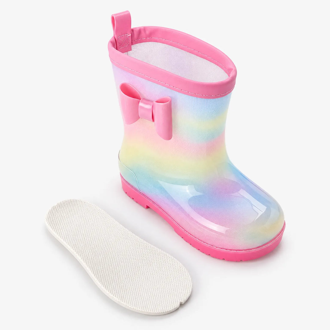 Single glittery rainbow welly with pink bow and pull tab, shown with its removable white textured insole beside it. 4