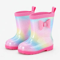 Pair of glittery rainbow wellies with water droplets on the surface, a pink bow, pull tabs and pink soles. 7