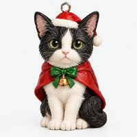Close-up of one black-and-white cat ornament in a Santa hat and red cape with a green bow and gold bell. 3