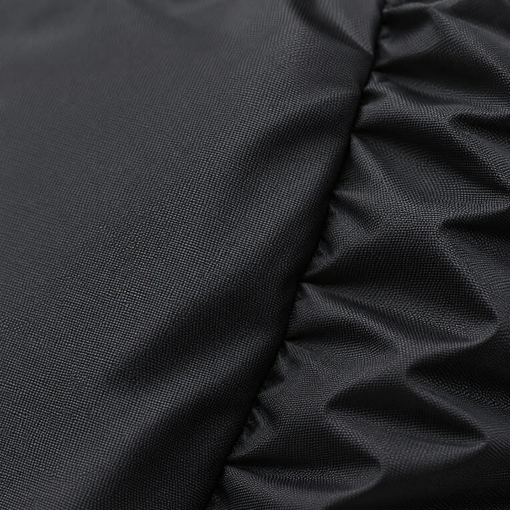 Close-up of the tightly woven black fabric, with a smooth panel on the left and gathered elastic folds on the right. 5