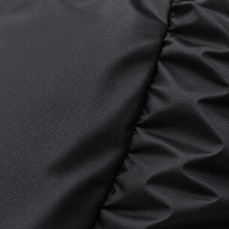 Close-up of the tightly woven black fabric, with a smooth panel on the left and gathered elastic folds on the right. 5