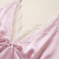 Close-up of the pink satin cami neckline, showing white eyelash lace trim and a small satin bow. 5