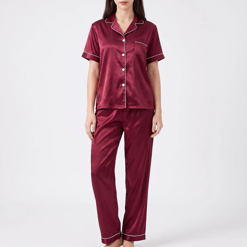Studio front view of a model wearing the burgundy satin pyjama set with contrast white piping and white buttons. 6