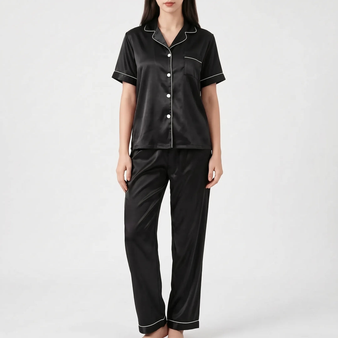 Model wearing the black satin version of the pyjama set with white piping and white buttons. 7