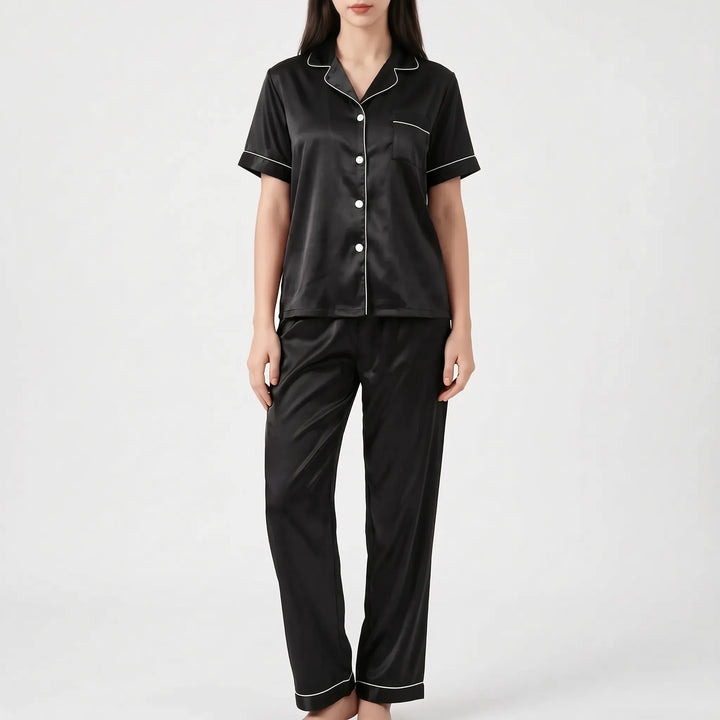 Model wearing the black satin version of the pyjama set with white piping and white buttons. 7