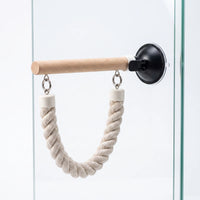 Single wooden perch fixed to glass by a black suction cup, with a U-shaped rope loop hanging beneath. 4