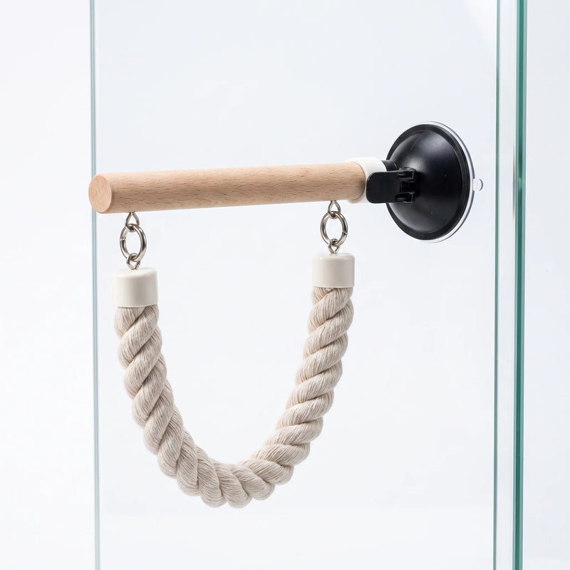 Single wooden perch fixed to glass by a black suction cup, with a U-shaped rope loop hanging beneath. 4