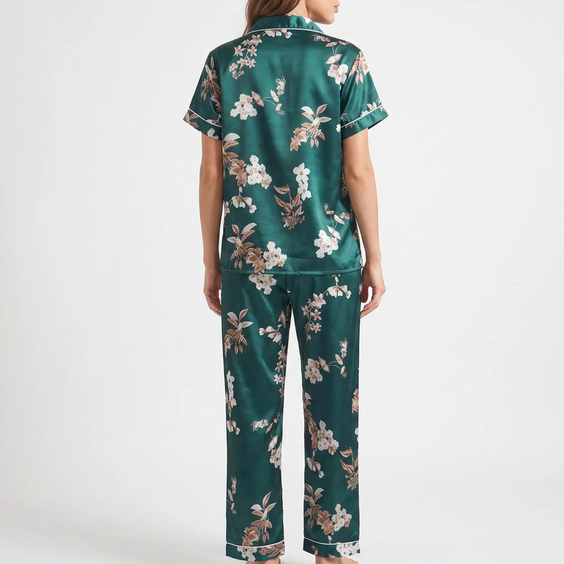 Back view of the model wearing the short-sleeve pyjama shirt and long trousers, showing the scattered white and tan floral print. 3