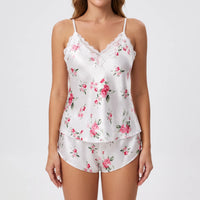 Front view on a model of the white satin pyjama set with pink roses and a lace-trimmed V-neck. 2